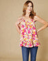 Woman wearing a colorful floral top against a beige background