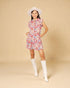 Woman wearing a floral dress and white boots on a beige background