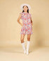Woman wearing a floral dress and white boots on a beige background
