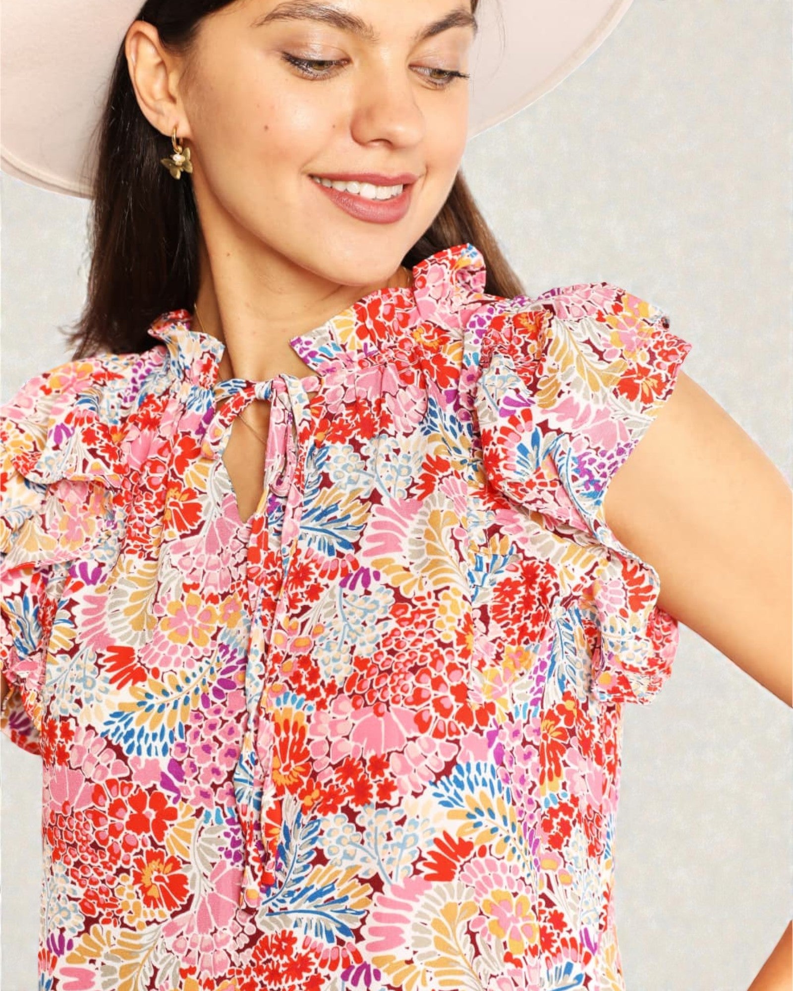 Woman wearing a colorful floral dress with a plain background