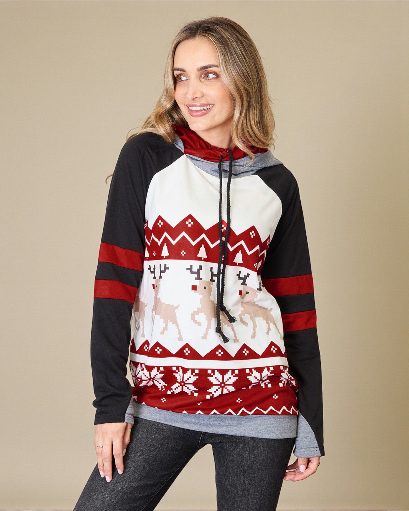 Woman wearing a festive sweater with reindeer and snowflake pattern on a beige background
