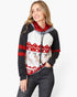 A woman modeling a holiday-themed raglan hoodie with a red and white Nordic pattern on the front, black sleeves, and a red hood lining, paired with dark gray jeans against a light gray studio background.