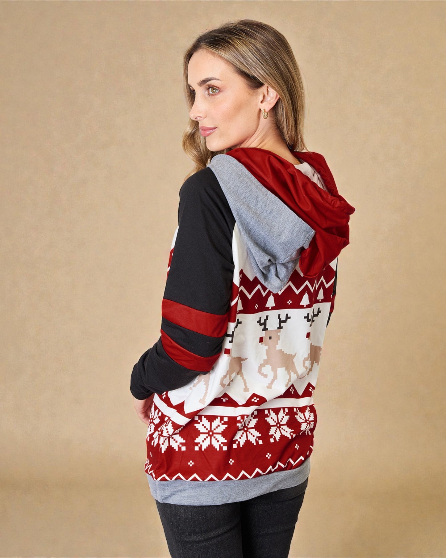 Woman wearing a red and black patterned sweater with a hood on a beige background