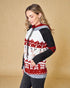 Woman wearing a festive hoodie with reindeer and snowflake pattern on a beige background
