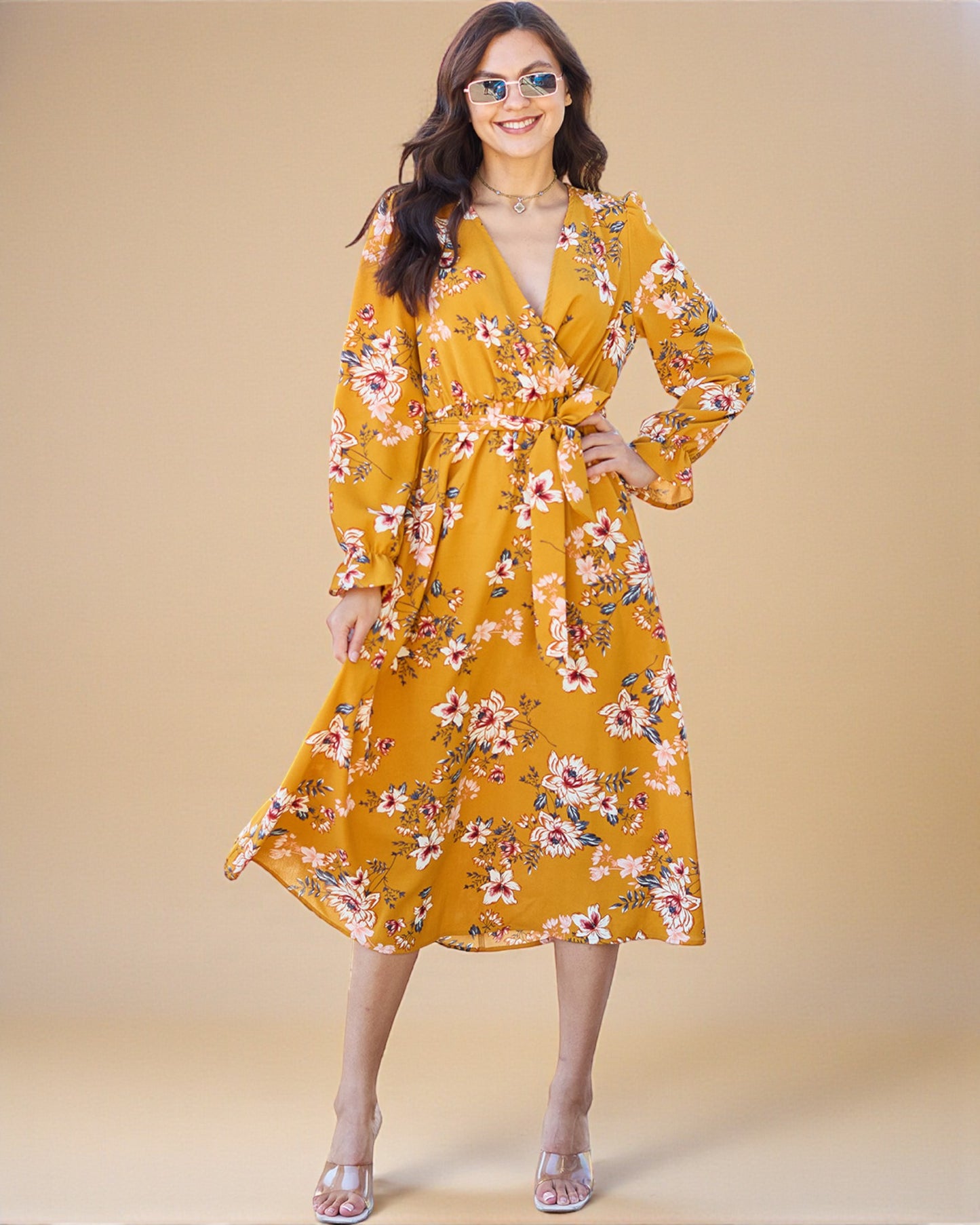 Woman wearing a yellow floral dress against a beige background
