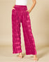 Person wearing bright pink patterned pants on a beige background