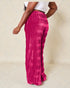 Person wearing bright pink tie-dye pants on a beige background