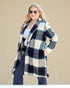 Woman wearing a blue and white checkered coat against a beige background