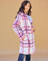 Woman wearing a pink and white plaid coat against a beige background