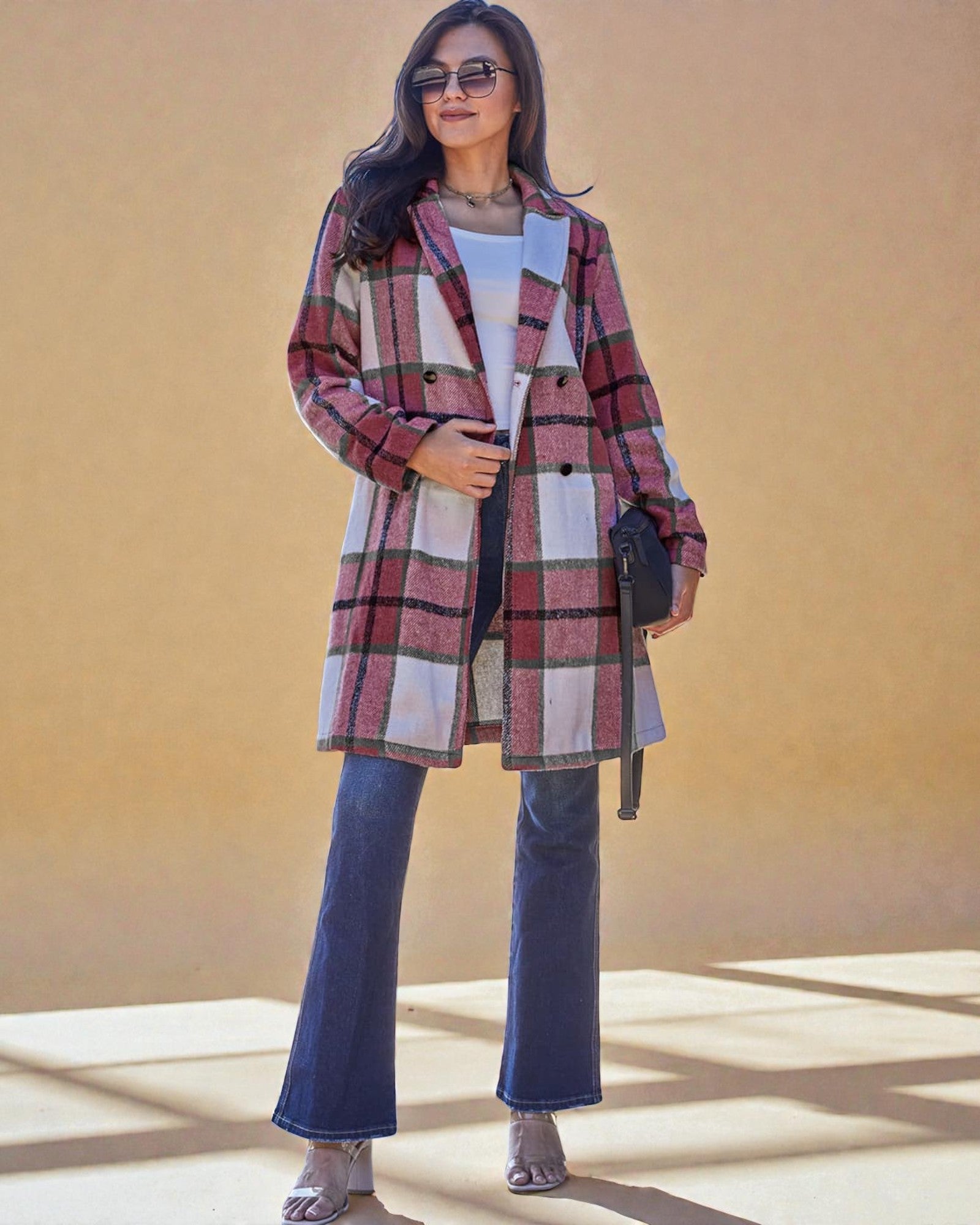 Woman wearing a plaid coat with a plain background