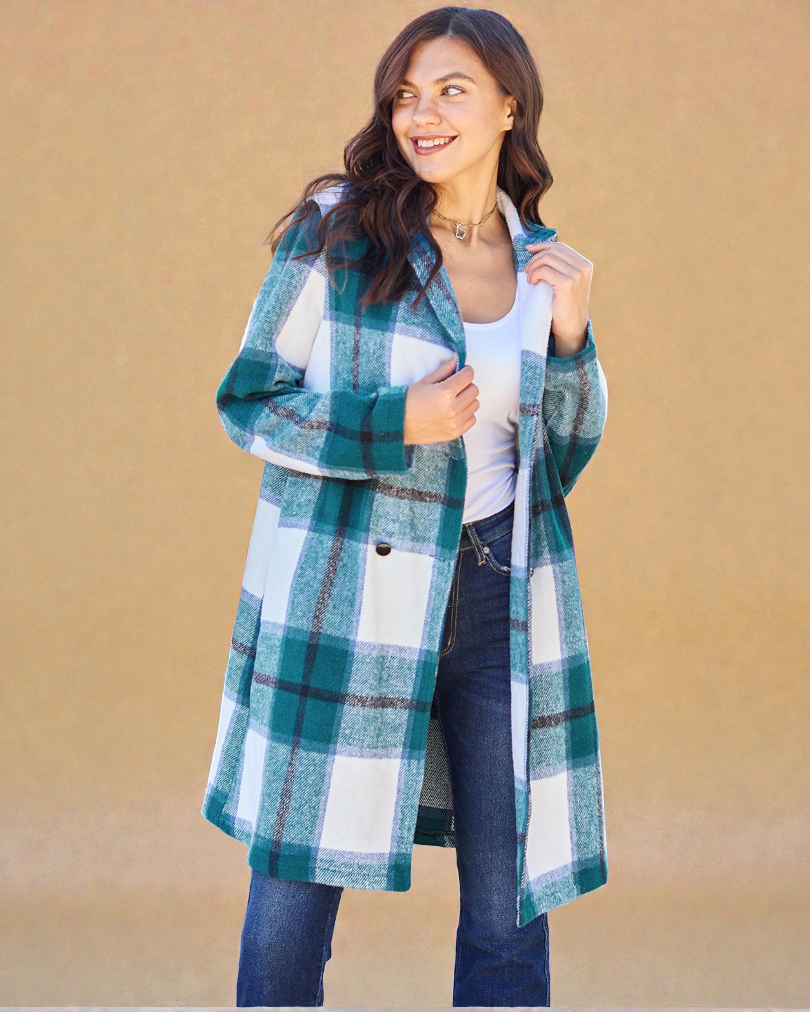 Woman wearing a green plaid coat against a beige background