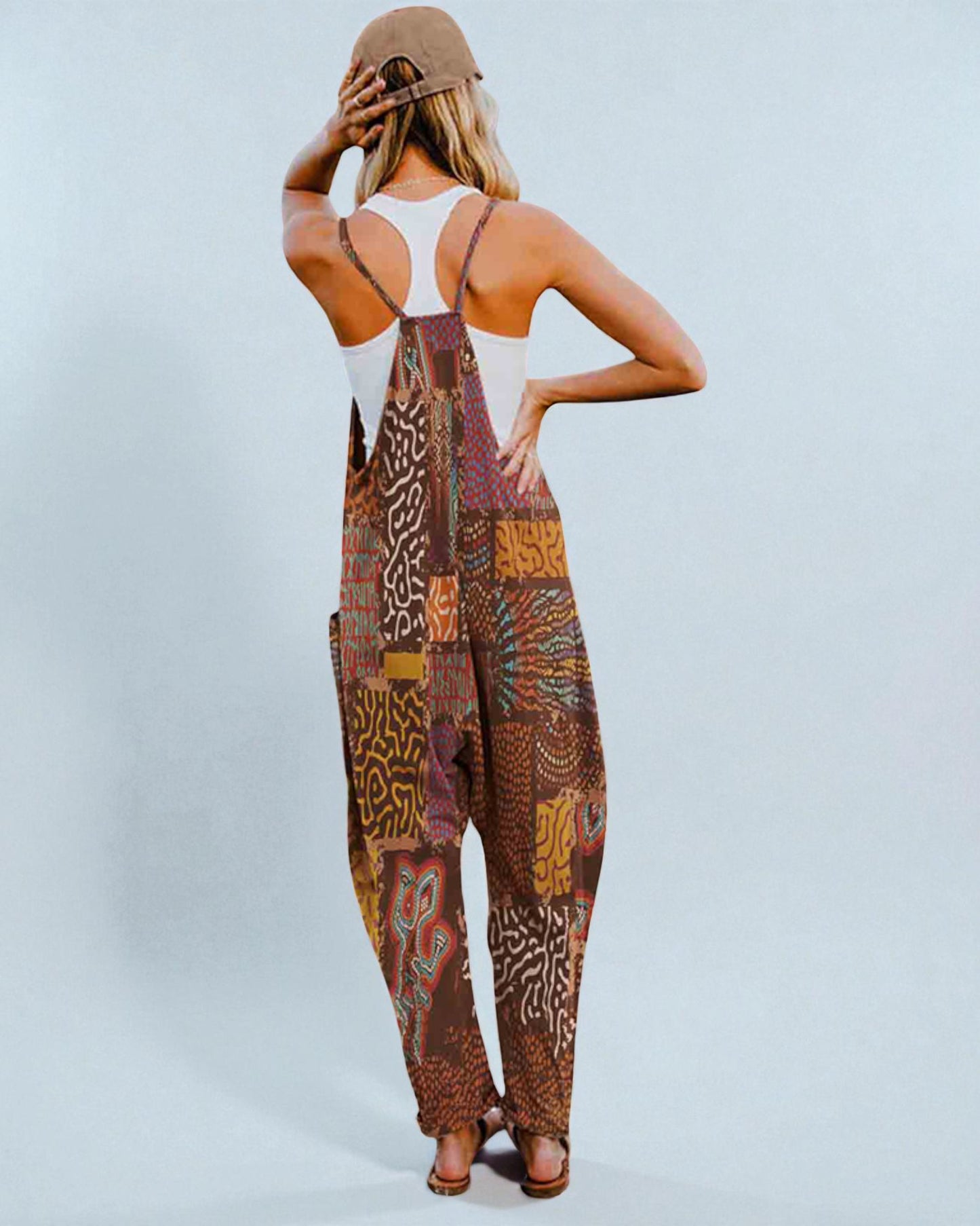 Woman wearing a patterned jumpsuit on a plain background