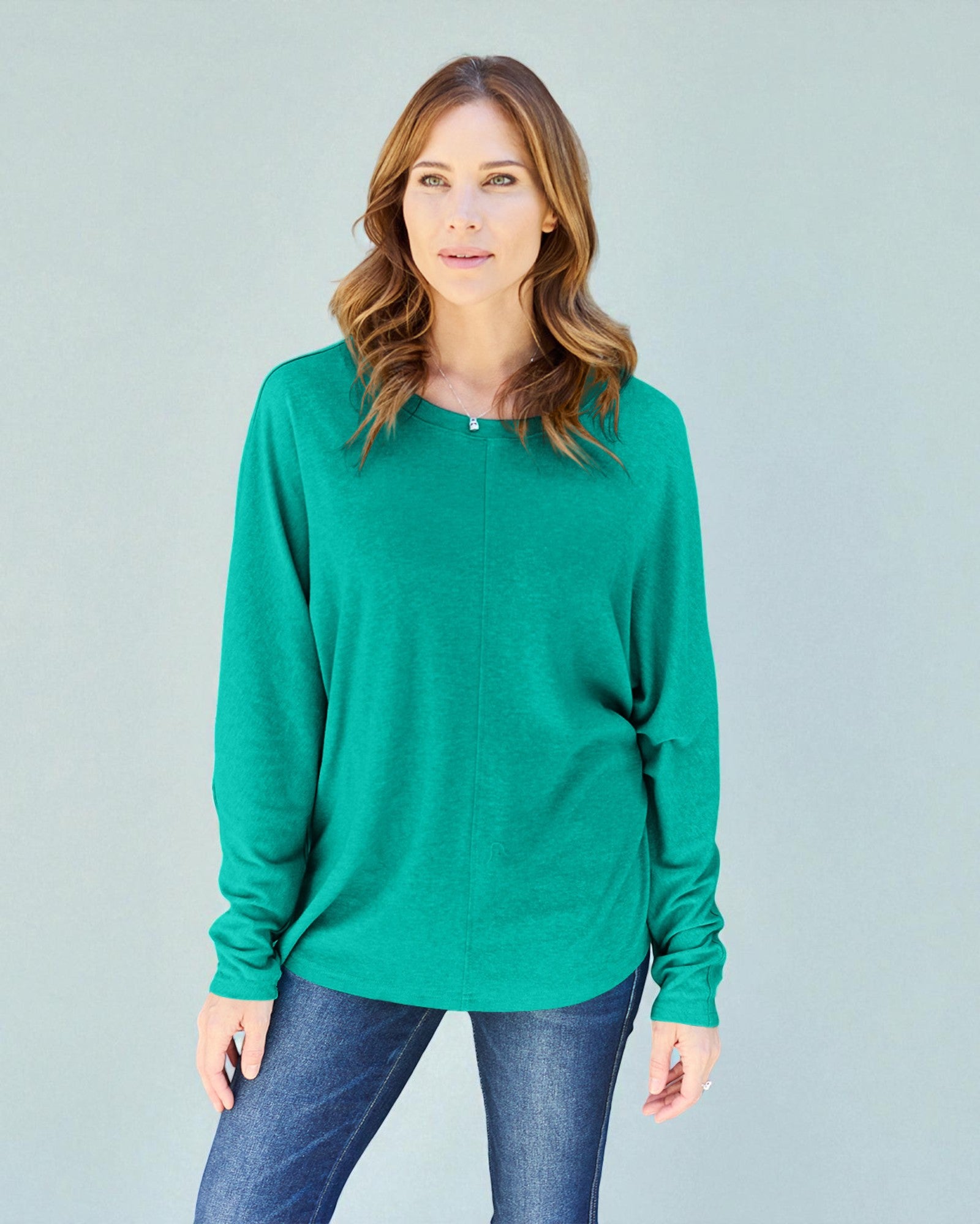 Woman wearing a green sweater against a gray background