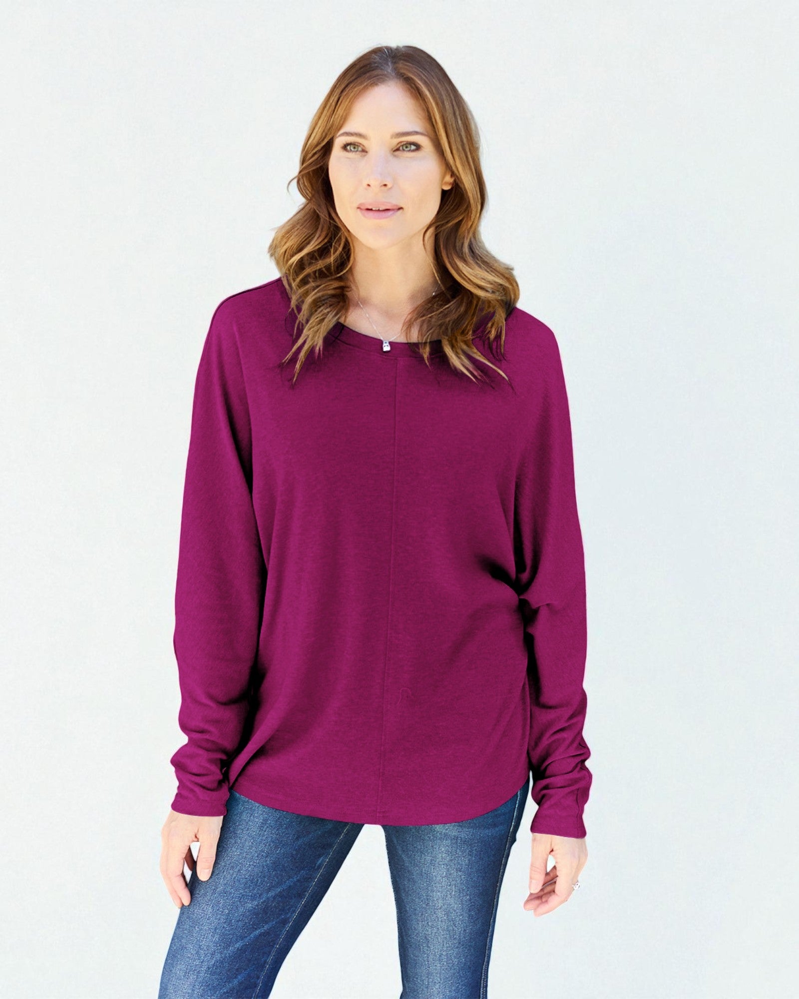 Woman wearing a purple long-sleeve top against a white background