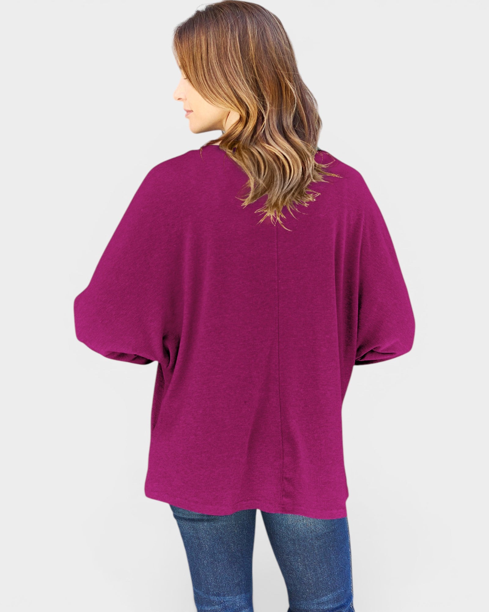 Person wearing a magenta oversized shirt on a white background