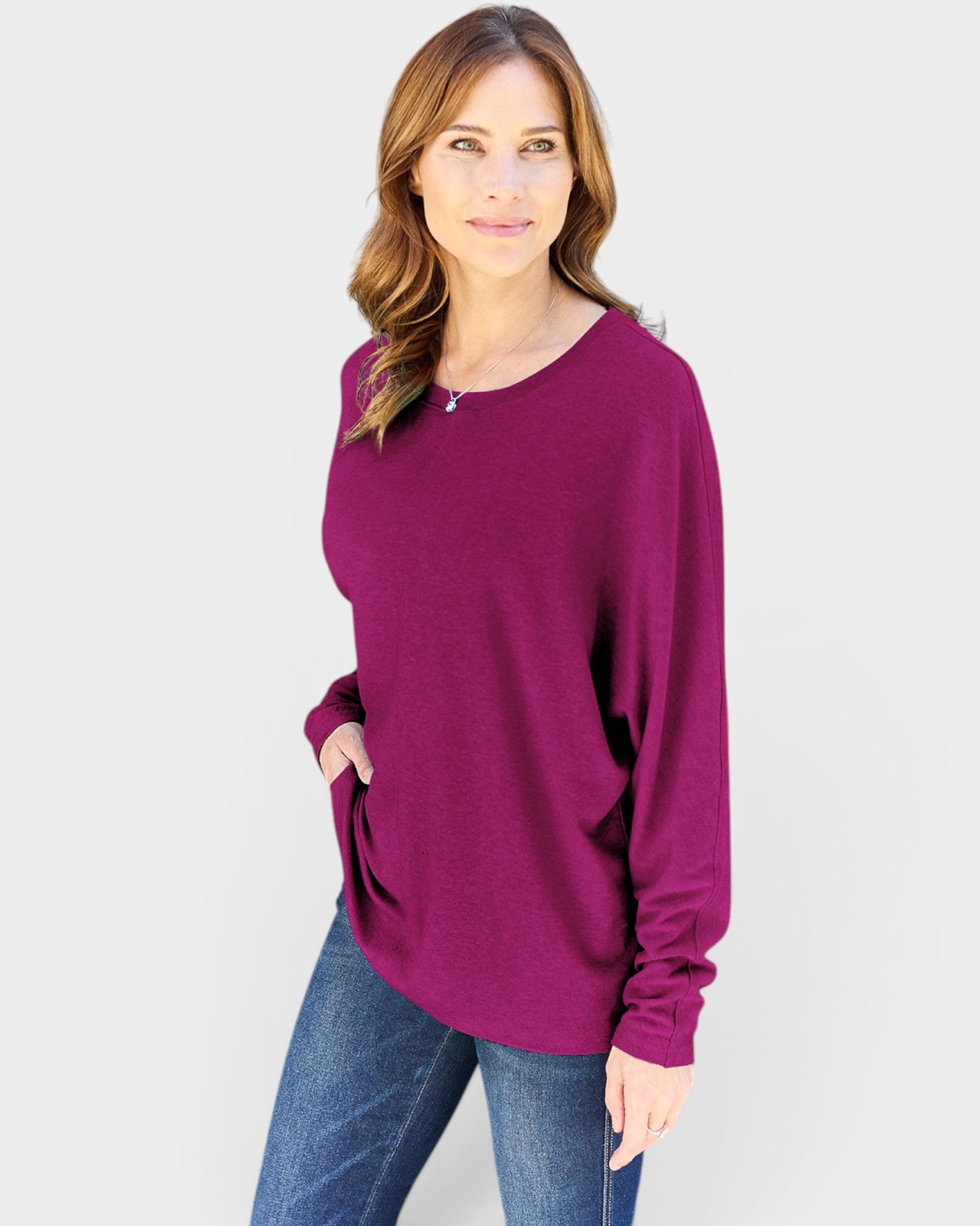 Woman wearing a purple sweater and blue jeans on a white background