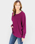 Woman wearing a purple sweater and blue jeans on a white background