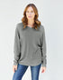 Woman wearing a gray long-sleeve top and blue jeans on a white background