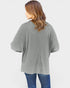 Person wearing a gray oversized sweater on a white background