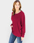 Woman wearing a red sweater and blue jeans on a white background