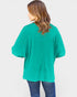 Person wearing a teal oversized shirt on a white background