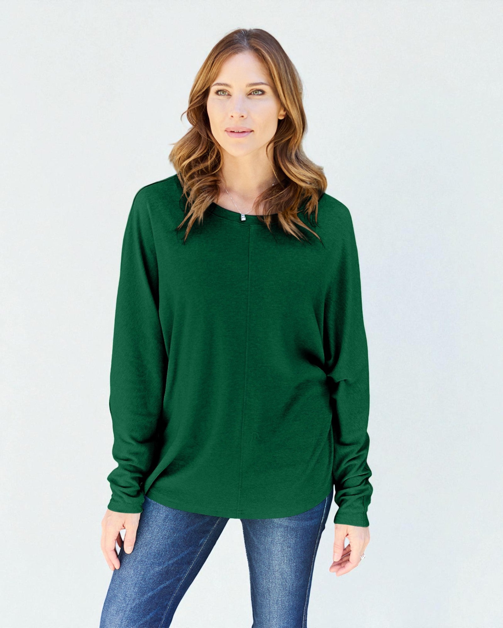 Woman wearing a green long-sleeve top against a white background