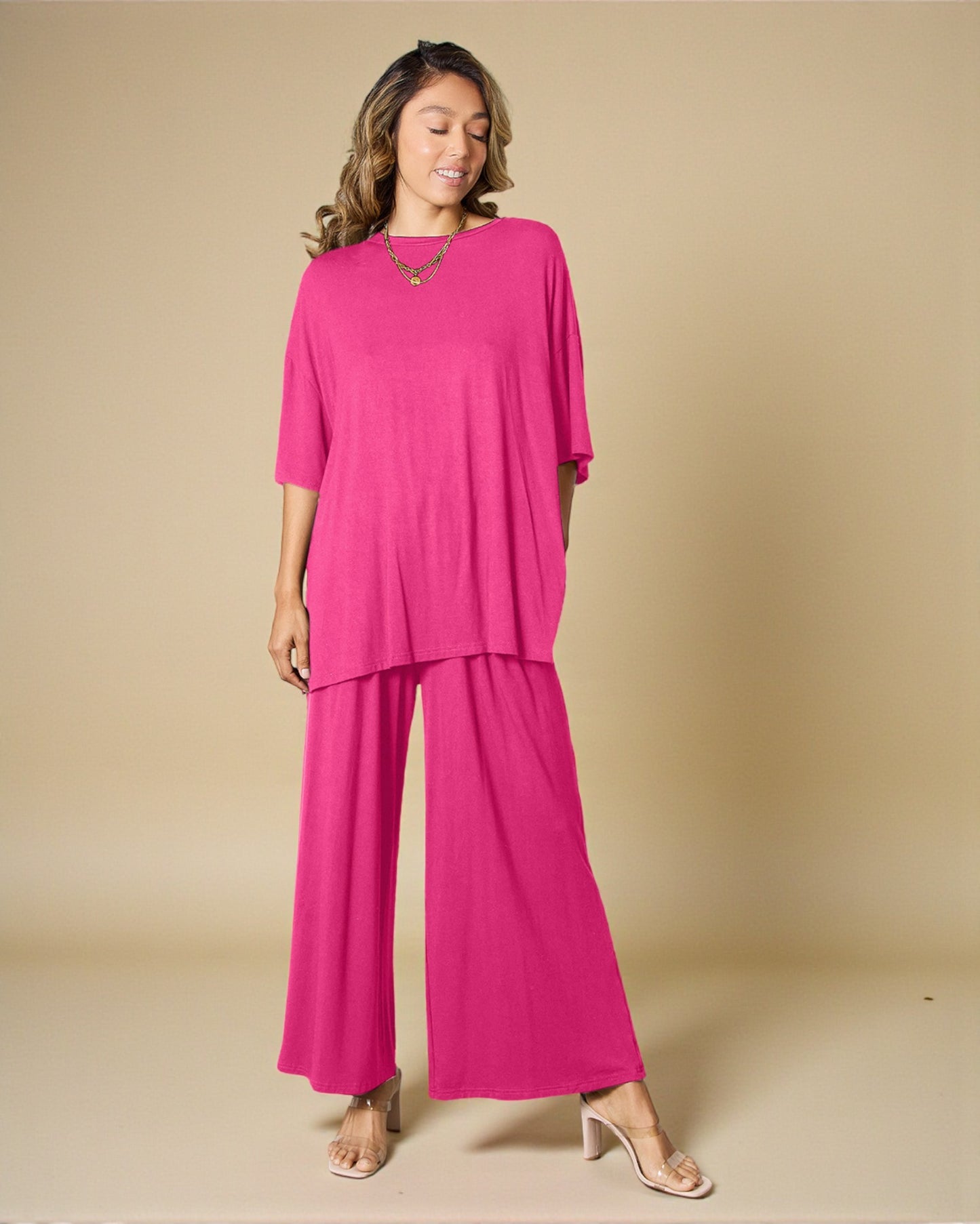 Woman wearing a bright pink outfit on a beige background