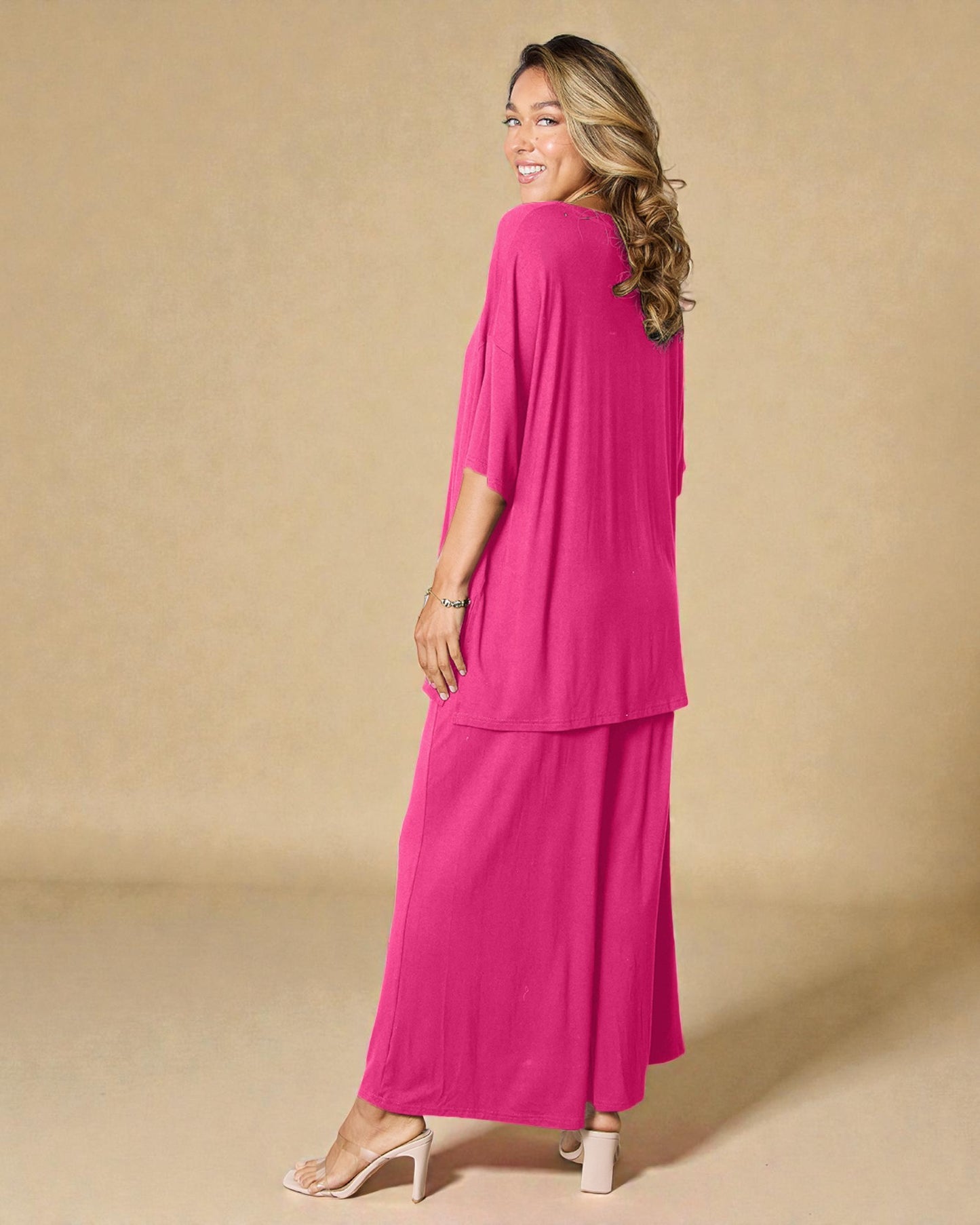 Woman wearing a pink outfit against a beige background