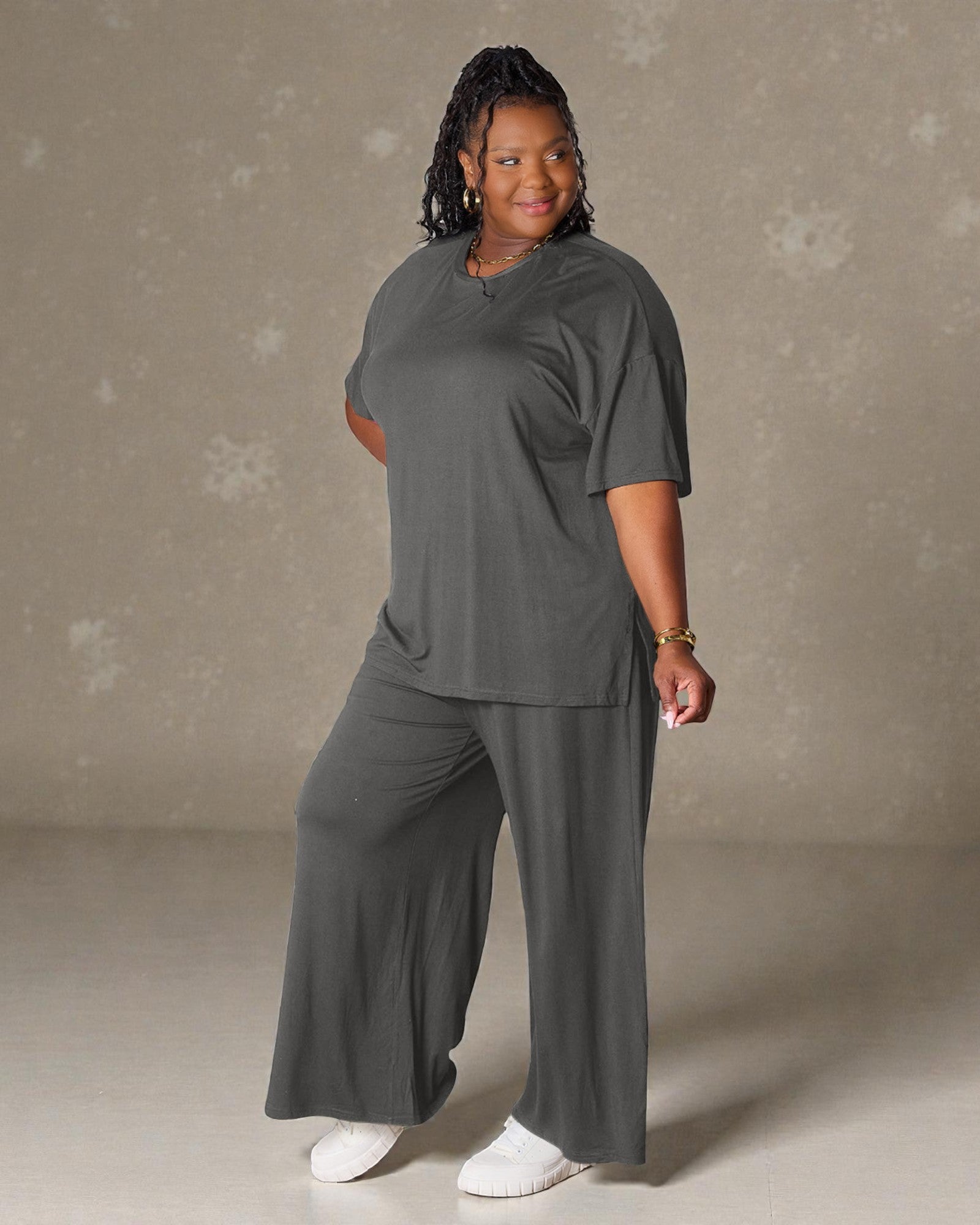 Person wearing a gray outfit against a neutral background