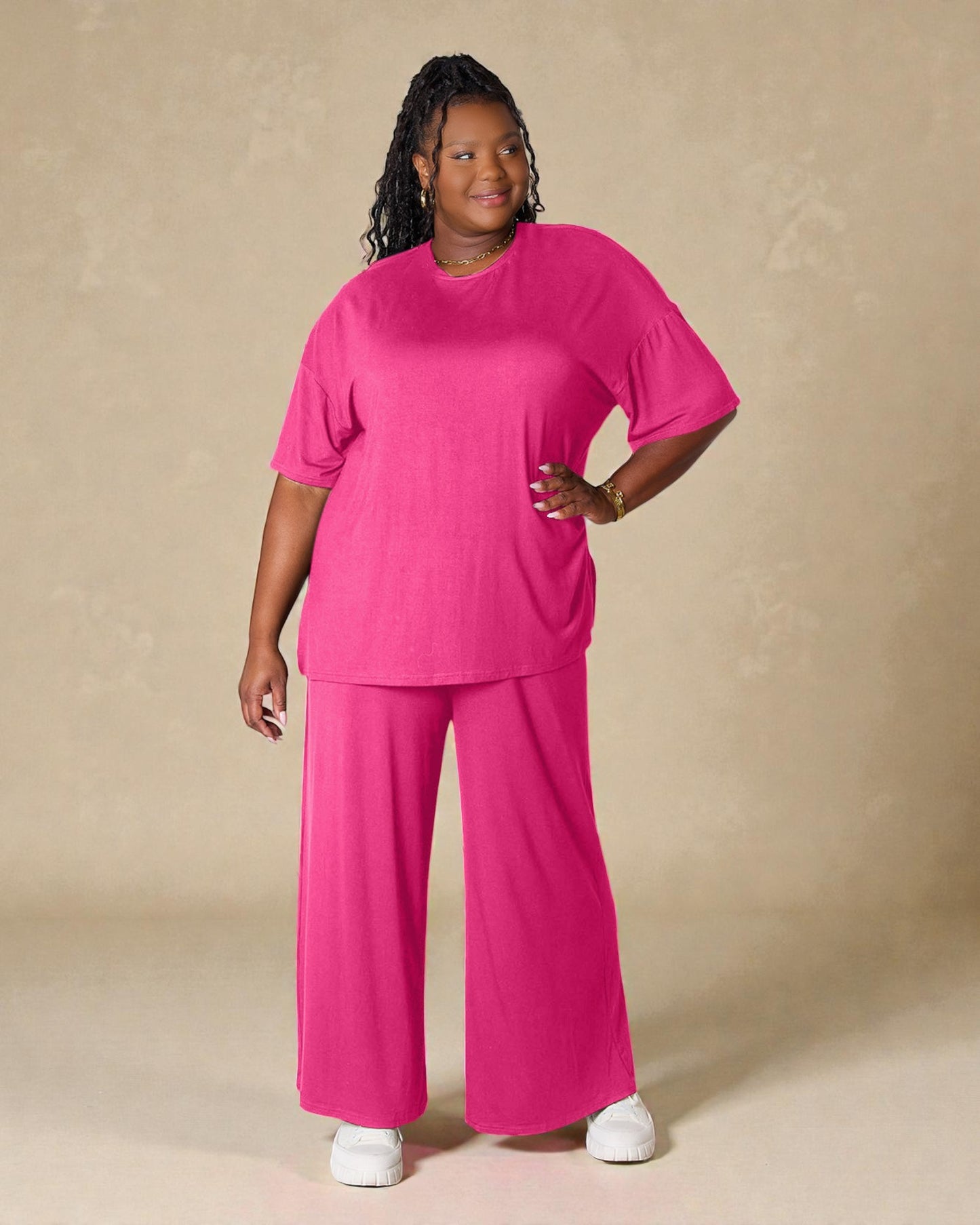 Woman wearing a bright pink outfit against a beige background