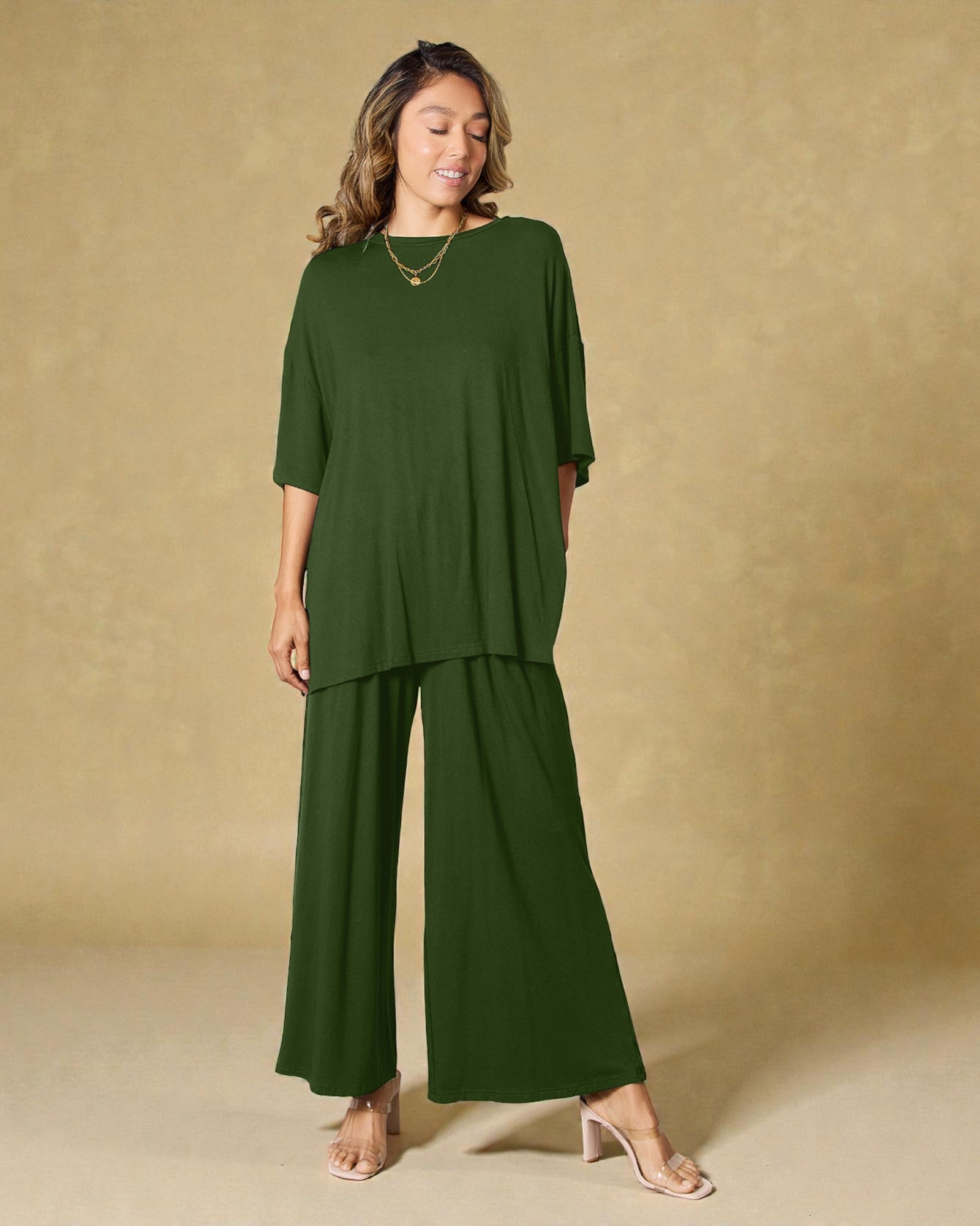 Woman wearing a green outfit against a beige background