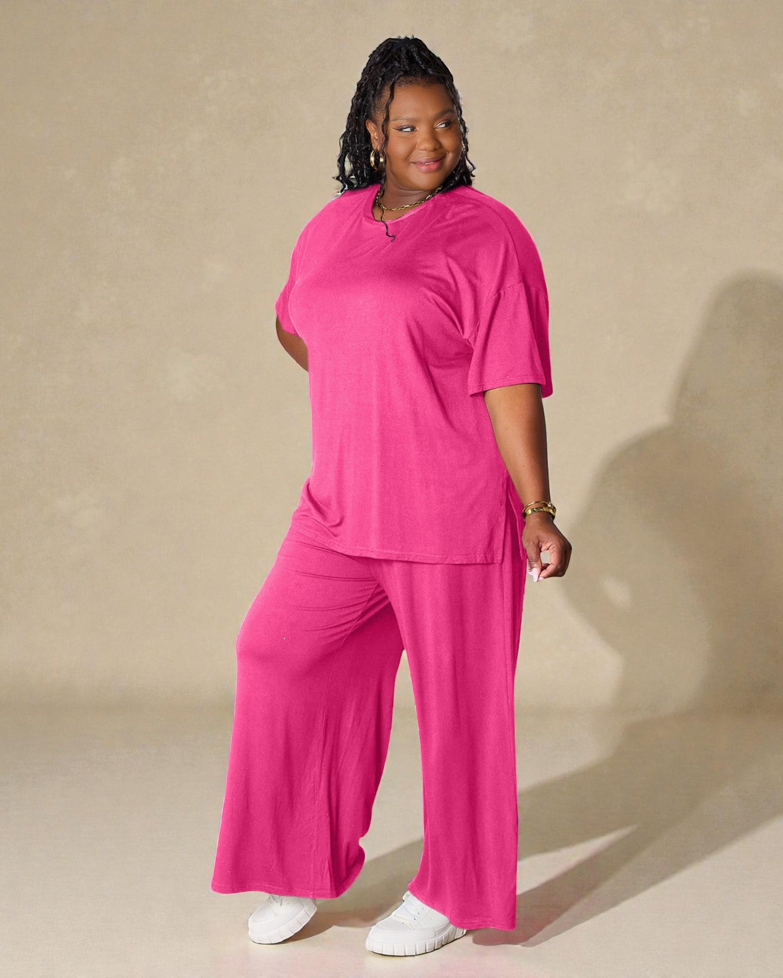 Woman wearing a bright pink outfit against a beige background