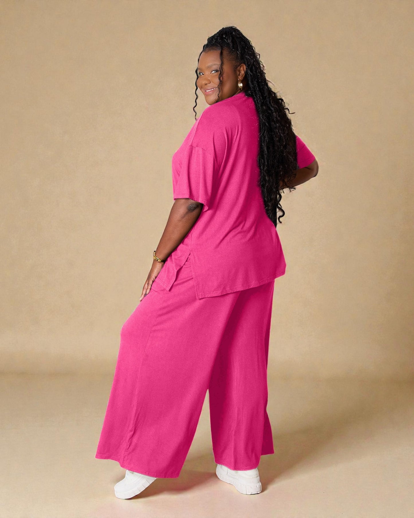 Woman wearing a bright pink outfit on a beige background