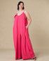 Woman wearing a pink jumpsuit against a beige background