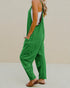 Person wearing a green jumpsuit against a beige background
