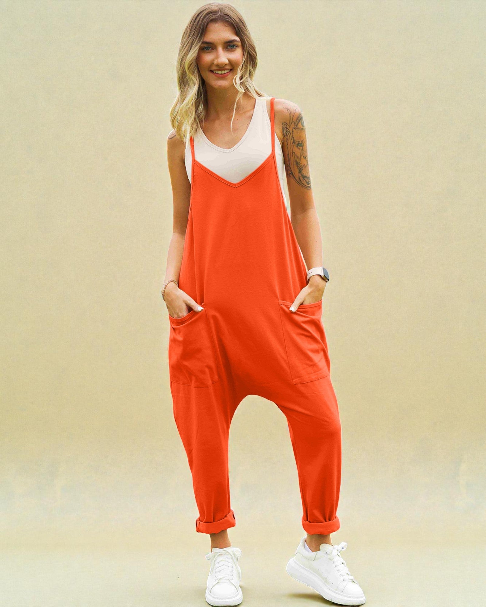 Woman wearing an orange jumpsuit with a beige background