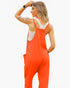 A woman wearing a bright orange jumpsuit over a white tank top, shown from the back against a plain white background.