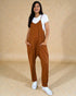 Woman wearing a brown jumpsuit with a white background
