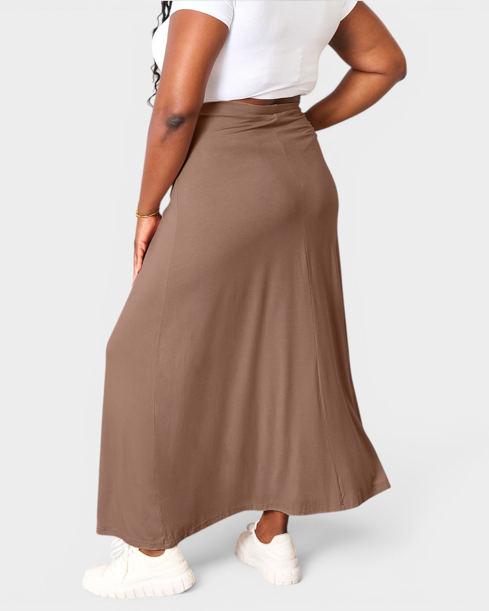 Person wearing a brown maxi skirt on a white background