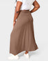 Person wearing a brown maxi skirt on a white background