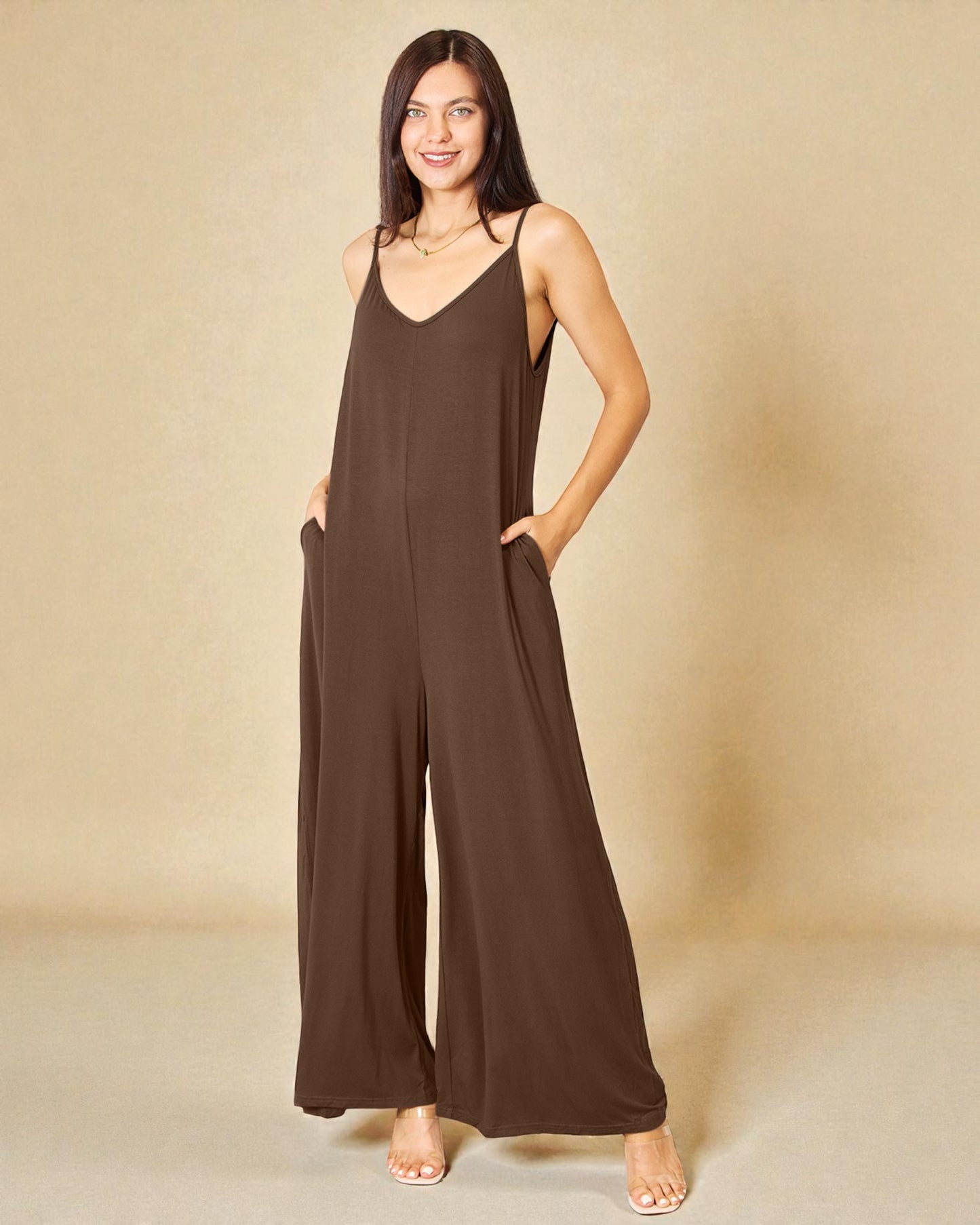 Woman wearing a brown jumpsuit against a beige background