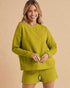Woman wearing a green outfit on a beige background