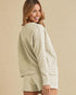 Woman wearing a light green textured outfit on a beige background