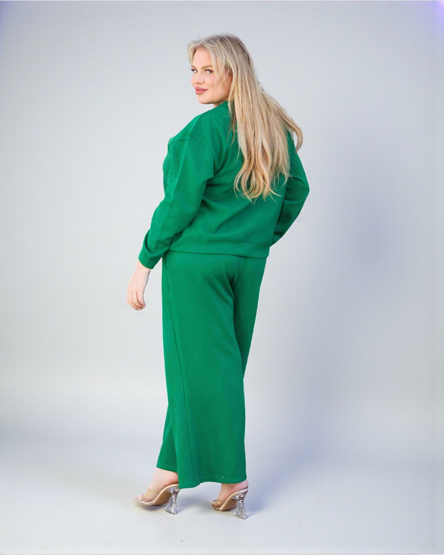 Woman wearing a green outfit on a plain background