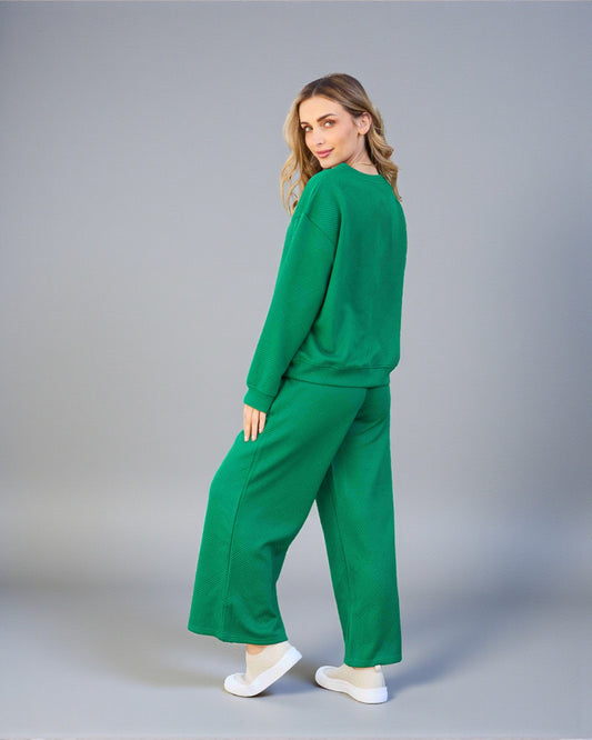 Woman wearing a green outfit on a gray background