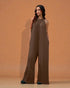 Woman wearing a brown jumpsuit against an orange background