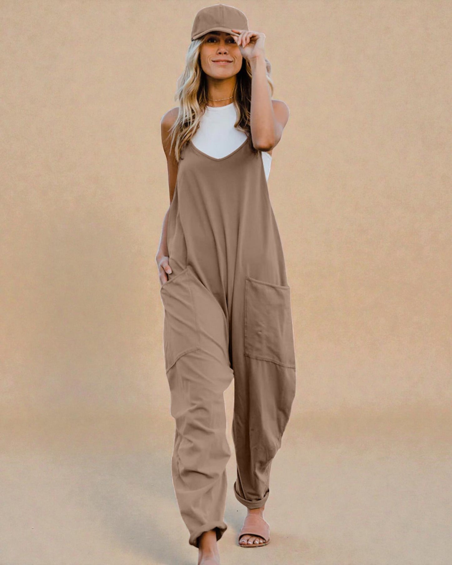 Woman wearing a beige jumpsuit against a beige background