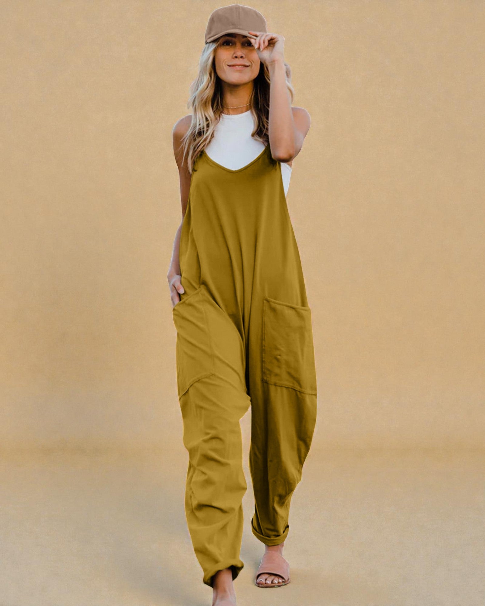 Woman wearing a mustard yellow jumpsuit against a beige background