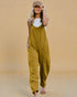 Woman wearing a mustard yellow jumpsuit against a beige background