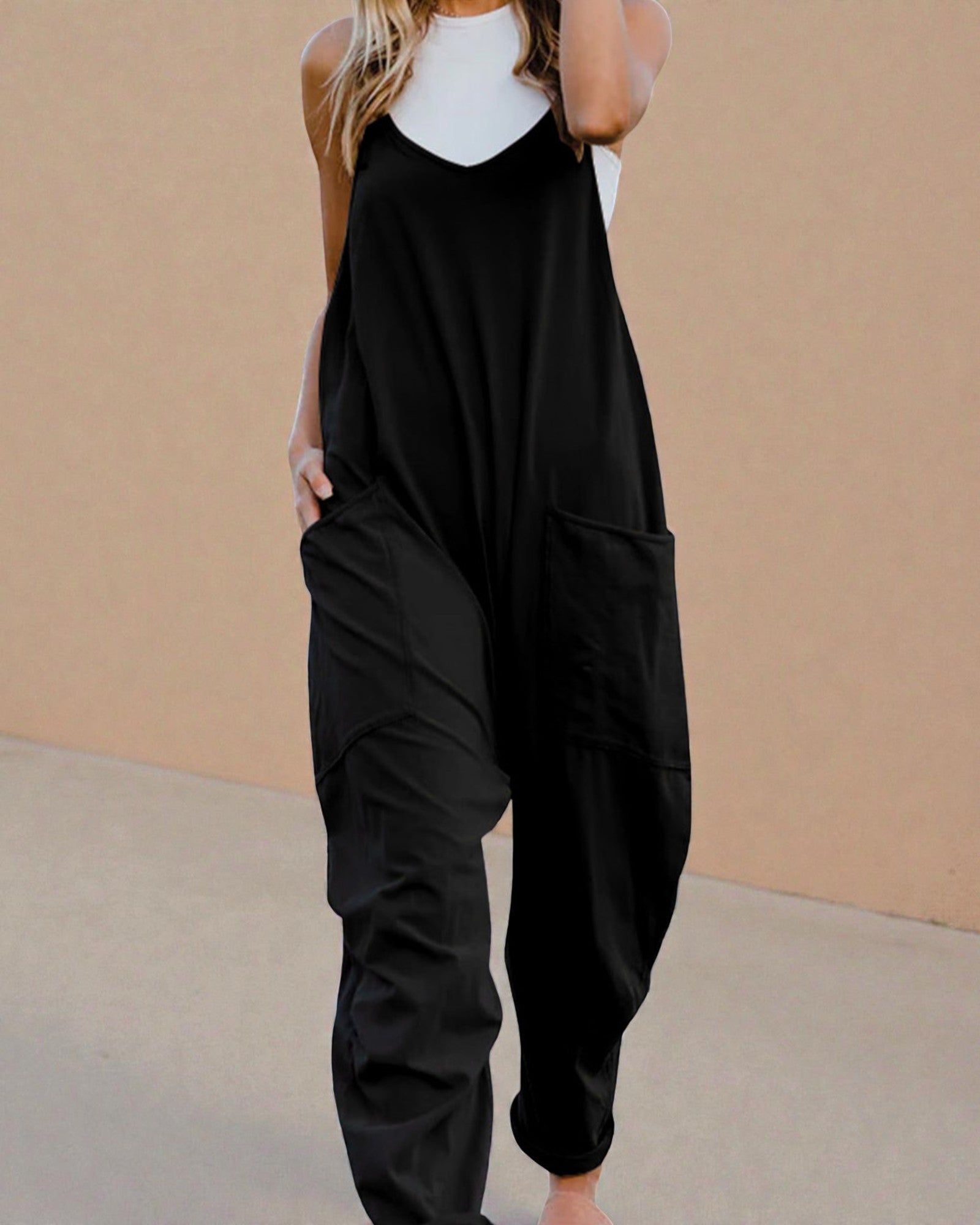 Black jumpsuit worn by a person against a beige background